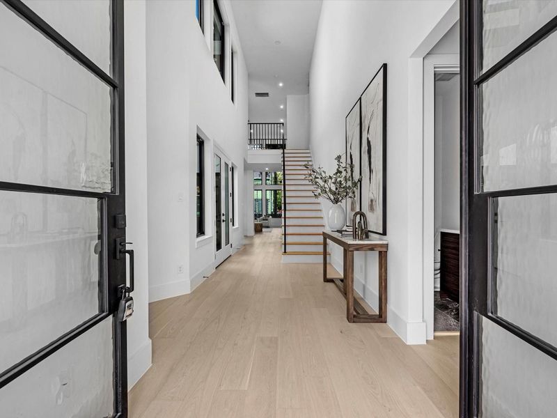 Step through the stunning double doors into a breathtaking open floor plan highlighted by soaring ceilings and walls of windows that fill the home with natural light. Just off the entry, a private study offers the perfect retreat for work or quiet focus.