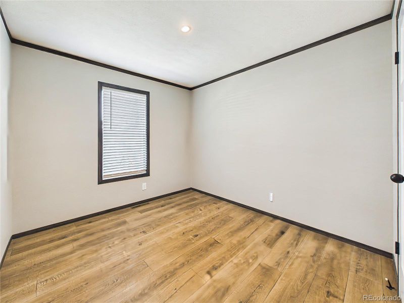 Bedroom 3– Bright and versatile bedroom with wide-plank flooring, neutral tones, and a window that brings in natural light.