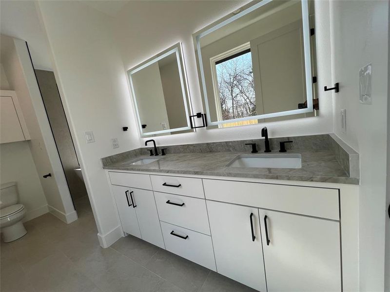 Bathroom with double vanity and toilet