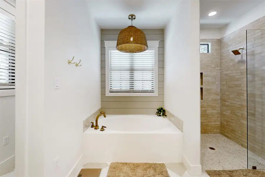 Full bathroom featuring a bath, tiled shower, and tile patterned floors
