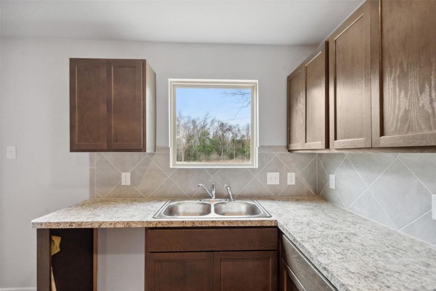 Enjoy a great view right from the kitchen sink, overlooking the beautiful backyard.