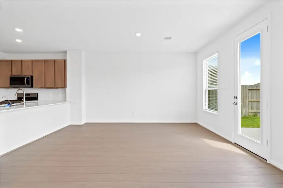 Start your day with a warm cup of coffee and quality time in this charming dining area! Highlights include a large window with blinds, custom neutral paint, vinyl plank flooring, recessed lighting, high ceilings, and a convenient door leading to the rear patio and backyard.