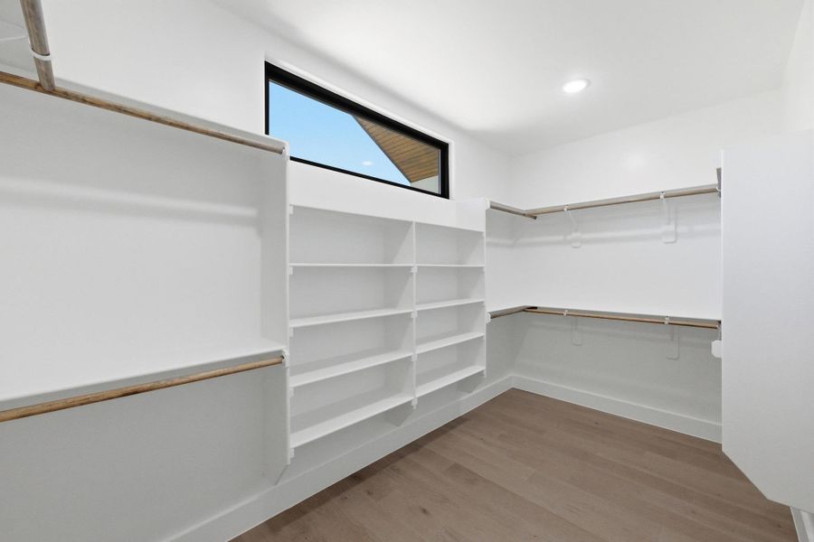 Walk in closet featuring light wood finished floors Walk in closet featuring light wood finished floors