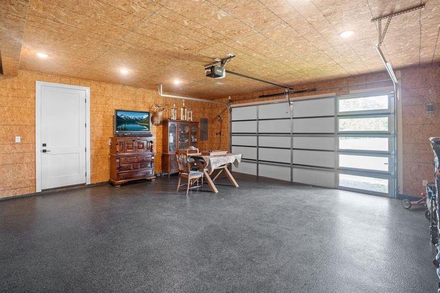 Garage featuring a garage door opener and electric panel Garage featuring a garage door opener and electric panel