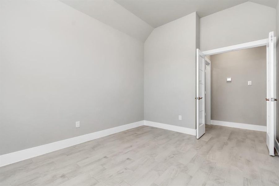 At the forefront of the home, a refined home office beckons productivity and focus. Luxurious details like tile flooring, custom paint, expansive windows with privacy blinds, and French doors create an inspiring workspace. Sample photo of completed home with similar floor plan. As-built interior colors and selections may vary.