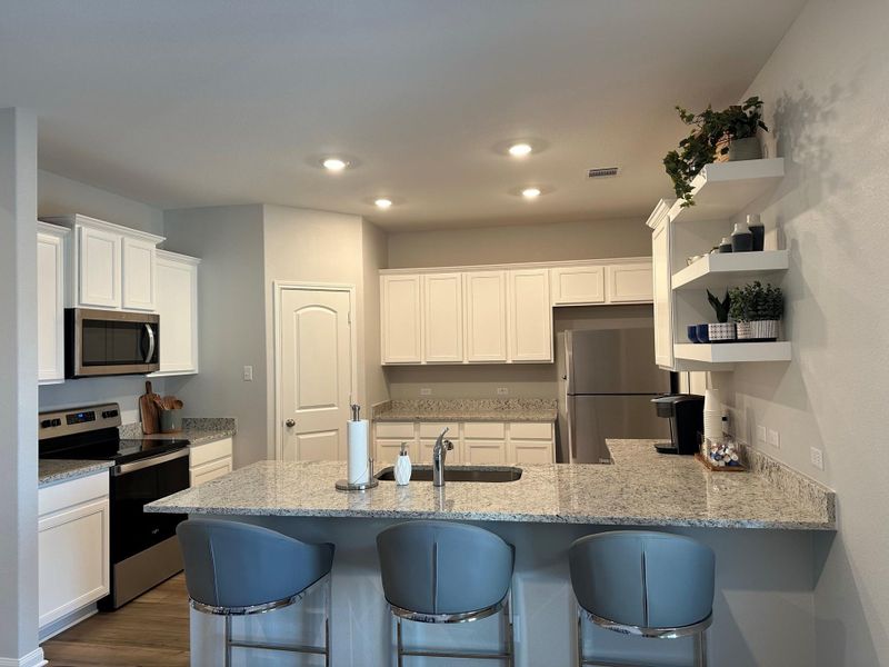 Kitchen includes granite countertops, luxury vinyl plank flooring, 36” upper cabinets with crown molding, a full suite of stainless-steel Whirlpool appliances – including refrigerator with ice maker, recessed lighting, and a large single basin sink.Pictures, floor plans, features, and colors are approximate for illustration purposes only. Home pictured may display decorative items, furniture and enhanced interior paint which are not available for purchase even upon additional payment.