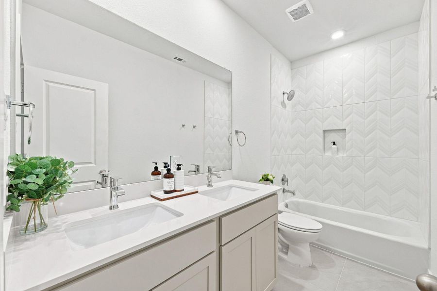 Spacious primary walk-in closet featuring multiple hanging areas and built-in shelving, offering generous storage and organization space. Spacious primary walk-in closet featuring multiple hanging areas and built-in shelving, offering generous storage and organization space.