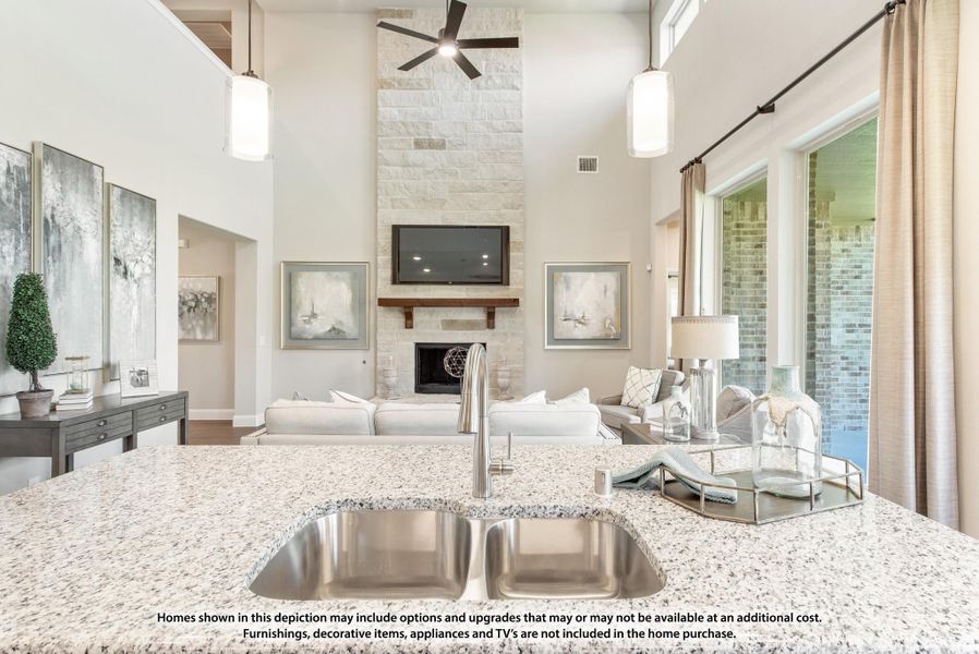 Open-concept kitchen with granite countertop and double sink overlooking living room with stone fireplace and high ceilings Open-concept kitchen with granite countertop and double sink overlooking living room with stone fireplace and high ceilings