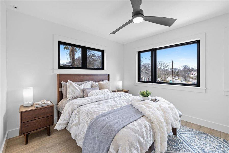 Bedroom featuring baseboards, light wood-style floors, and a ceiling fan