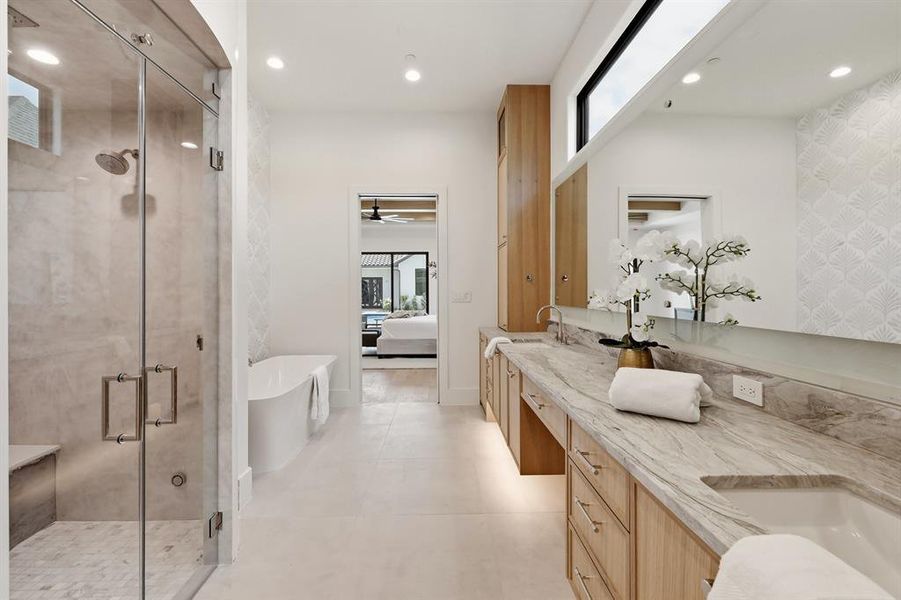 Primary bath offers a steam shower, heated tile floors, soaking tub, dual closets and dedicated washer/dryer
