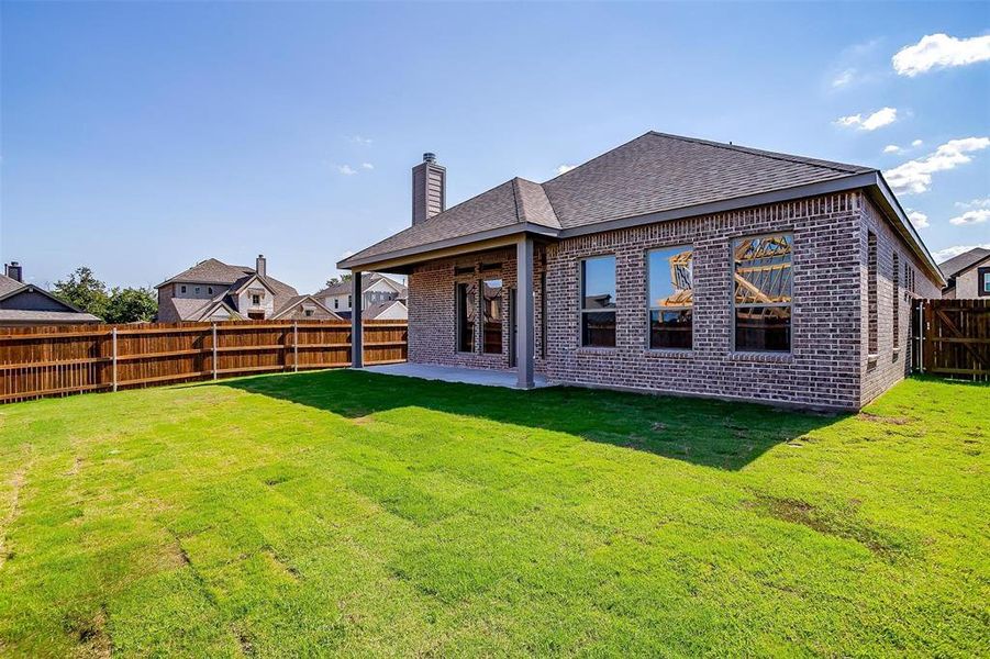 Rear view of property with a patio area and a yard