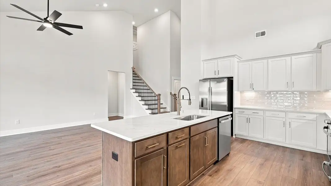 Highly skilled craftsmanship shines in this modern kitchen with high ceilings and a central island focal point
