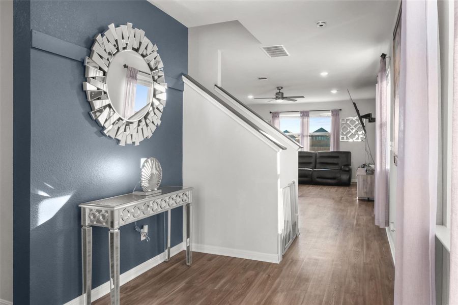 Hall featuring wood finished floors, stairs, and recessed lighting