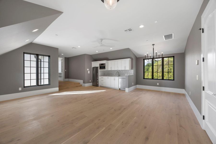 A spacious recreation room, bathed in natural light, features ample space for leisure and a convenient wet bar. A spacious recreation room, bathed in natural light, features ample space for leisure and a convenient wet bar.