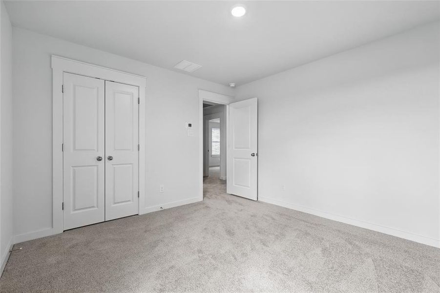 Unfurnished bedroom with carpet flooring, baseboards, and a closet Unfurnished bedroom with carpet flooring, baseboards, and a closet