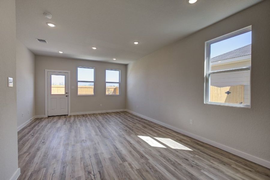 A room with a wood floor and windows.