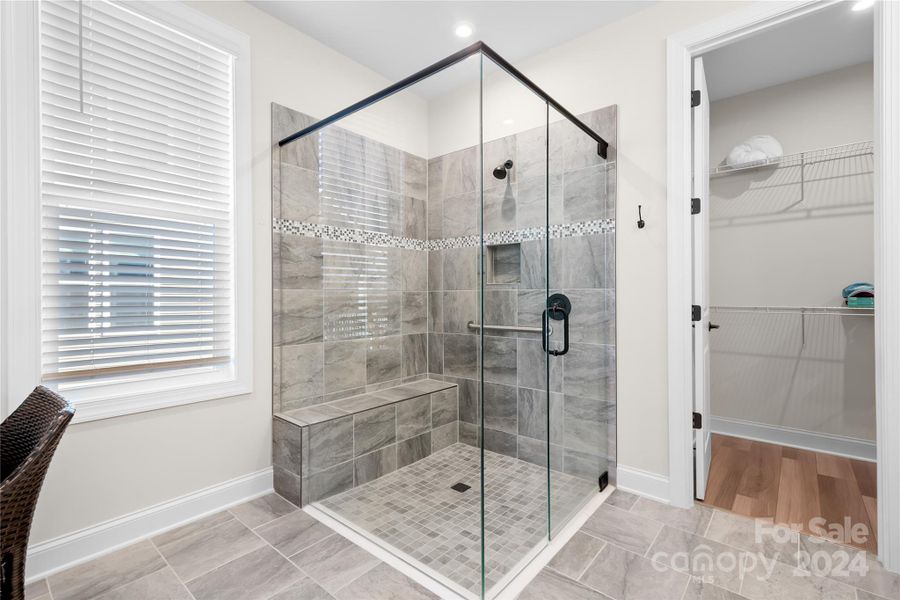 Every day wi;; feel like Spa Day in your fully-tiled  "jewel box" shower that features a tiled bench, grab bar, and shampoo niche and has no curb for easy and safe entry.