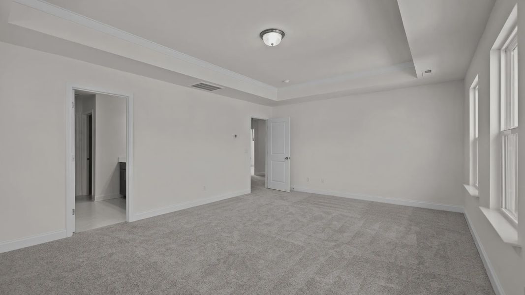 Burton Design oversized primary bedroom with raised tray ceiling and large windows. By DRB Homes at Lakeside Glen in York, SC Burton Design oversized primary bedroom with raised tray ceiling and large windows. By DRB Homes at Lakeside Glen in York, SC