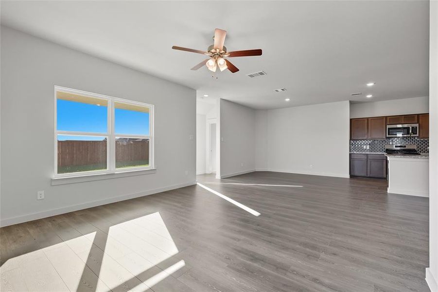 Unfurnished living room with dark wood finished floors, a ceiling fan, and recessed lighting Unfurnished living room with dark wood finished floors, a ceiling fan, and recessed lighting