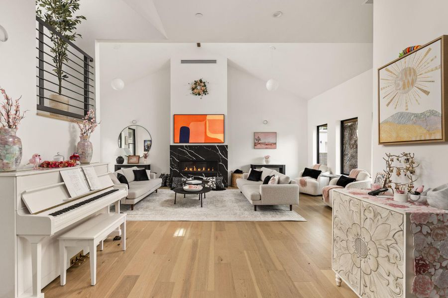 A striking black marble fireplace serves as the focal point in this inviting living space with high vaulted ceilings. A striking black marble fireplace serves as the focal point in this inviting living space with high vaulted ceilings.