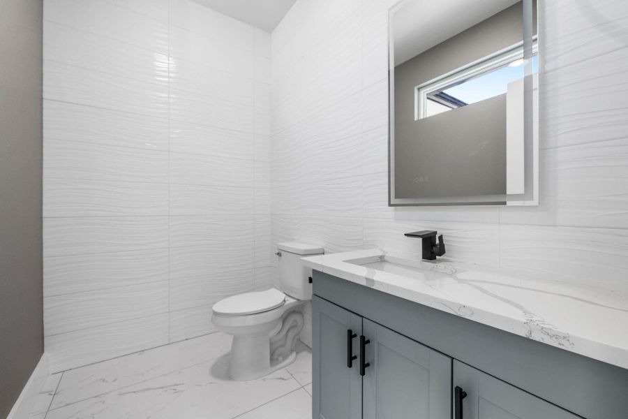 1/2 Bathroom with tiled walls.