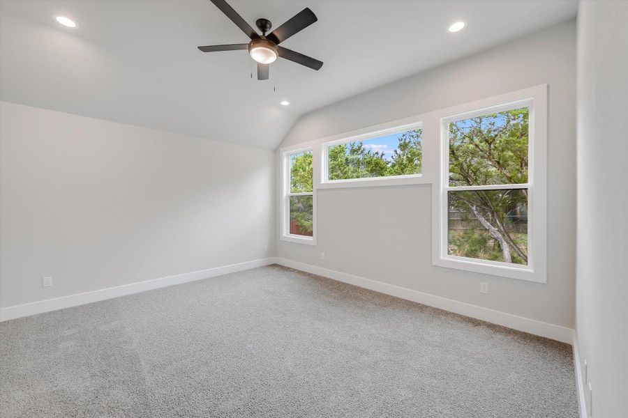 Carpeted spare room featuring recessed lighting, vaulted ceiling, baseboards, and ceiling fan