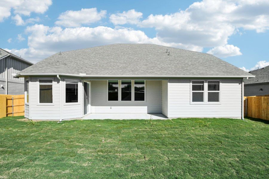 Back of house featuring a fenced backyard, a patio, and a shingled roof