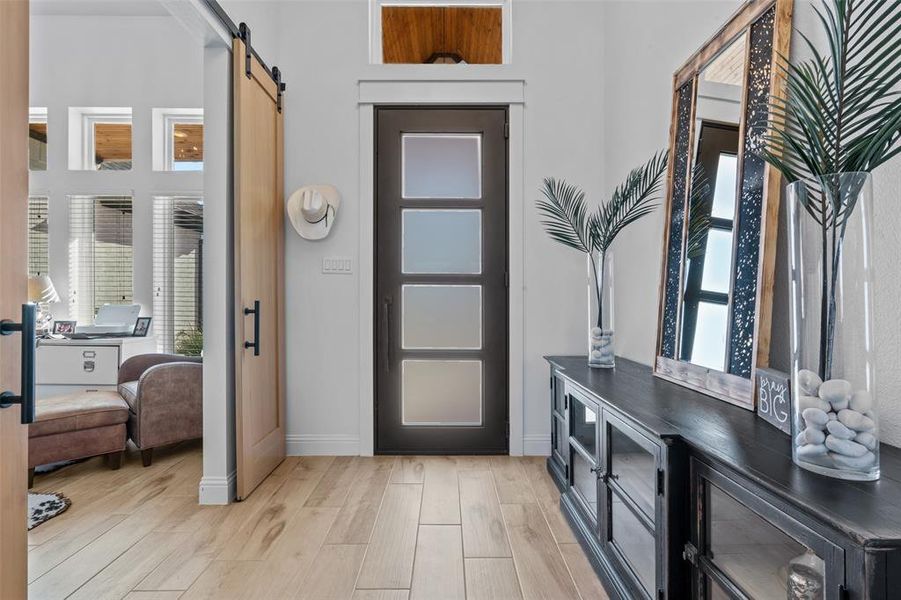 Foyer featuring a barn door, plenty of natural light, and light wood-type flooring