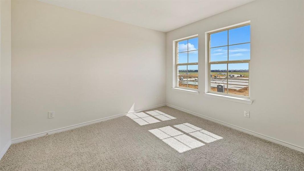 Empty room featuring carpet flooring and baseboards