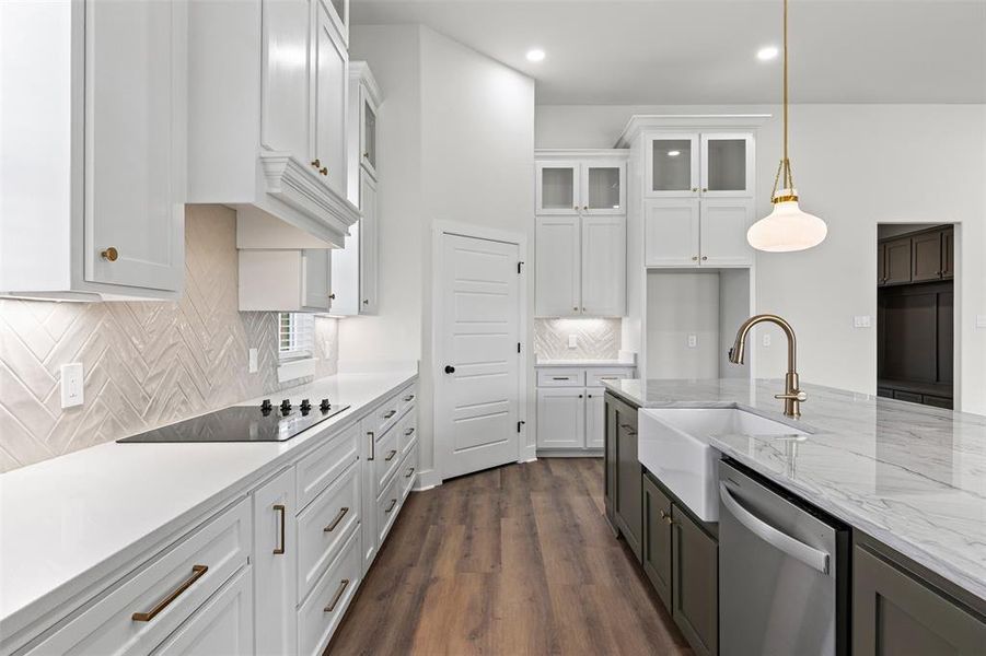 Kitchen featuring white cabinetry, light stone countertops, dark wood-style flooring, backsplash, and glass insert cabinets Kitchen featuring white cabinetry, light stone countertops, dark wood-style flooring, backsplash, and glass insert cabinets