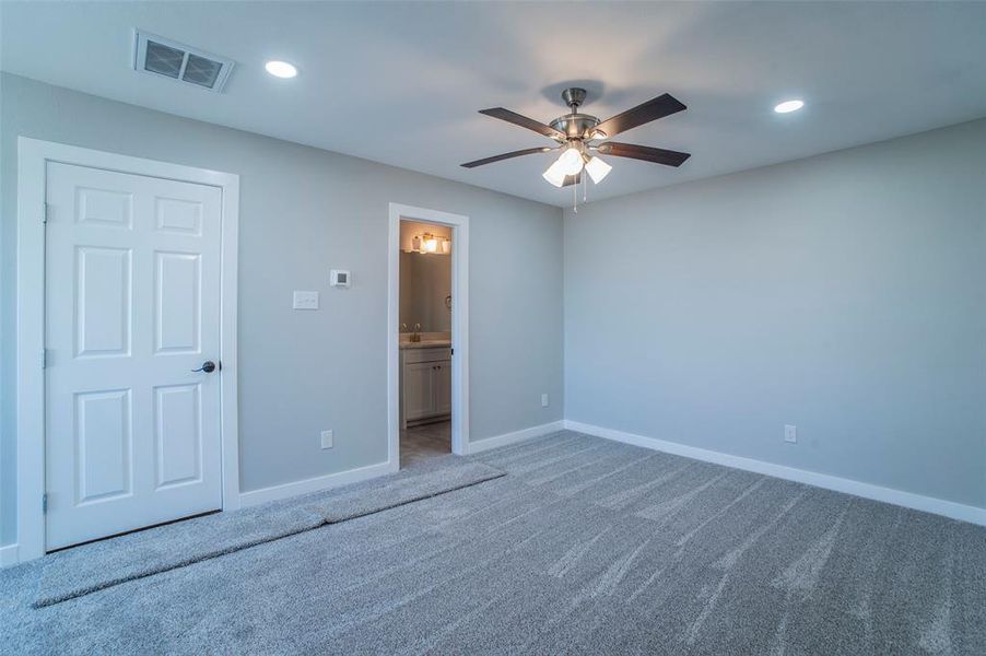 Unfurnished bedroom with recessed lighting, ensuite bathroom, carpet, and a ceiling fan Unfurnished bedroom with recessed lighting, ensuite bathroom, carpet, and a ceiling fan