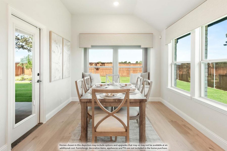 Dining area with wood table, six chairs, vaulted ceiling, and large windows overlooking a backyard