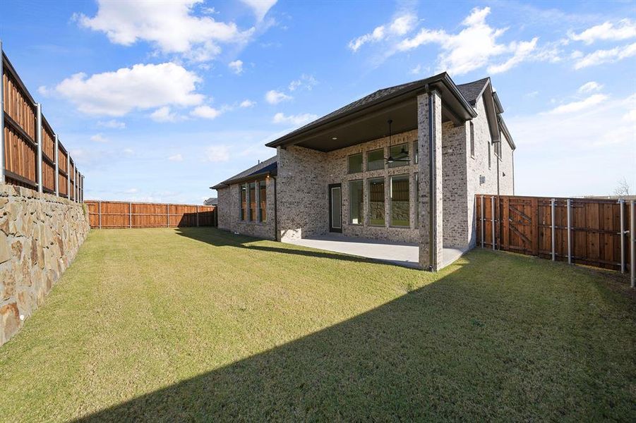 Back of house featuring a patio area, brick siding, and a fenced backyard