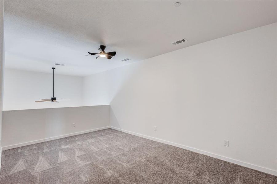 Unfurnished room with light colored carpet and ceiling fan