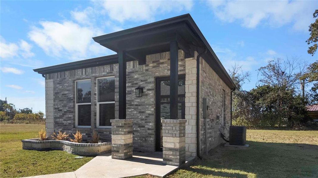 View of home's exterior featuring a yard, brick siding, and stone siding