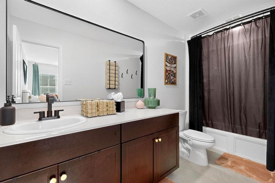 Bathroom with shower / bath combo, vanity, and light tile patterned flooring Bathroom with shower / bath combo, vanity, and light tile patterned flooring