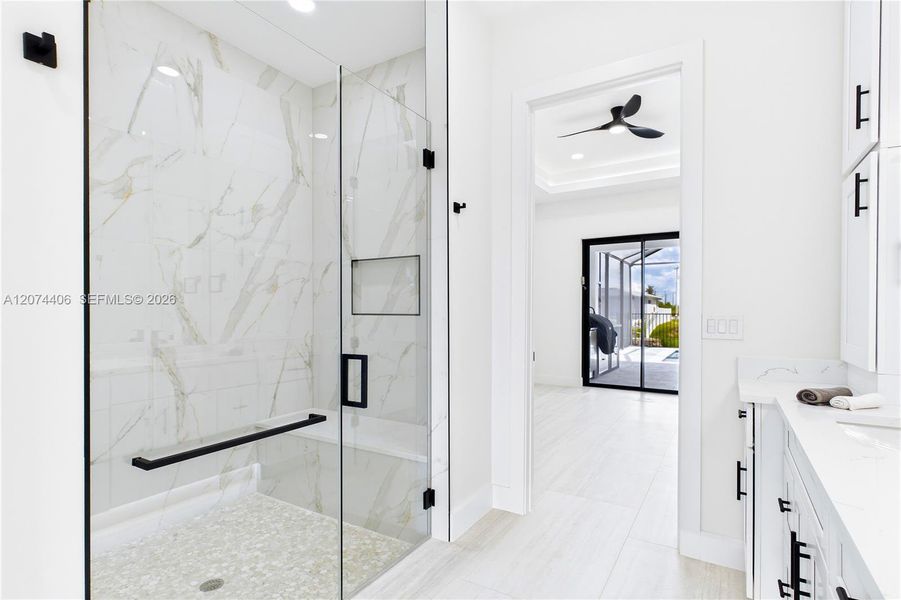 LUXURIOUS PRIMARY BATHROOM w/ spacious WALK-IN GLASS SHOWER w/ floor-to-ceiling designer tile, rainfall showerhead, built-in bench & modern matte-black fixtures LUXURIOUS PRIMARY BATHROOM w/ spacious WALK-IN GLASS SHOWER w/ floor-to-ceiling designer tile, rainfall showerhead, built-in bench & modern matte-black fixtures