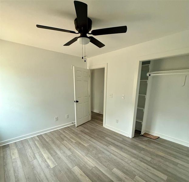 Unfurnished bedroom with a ceiling fan, light wood finished floors, and a closet