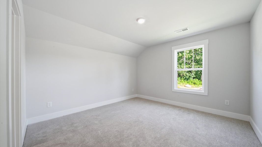Memorable secondary bedroom walk-in closet, soft carpeting, and striking natural light from large windows in Anderson, SC