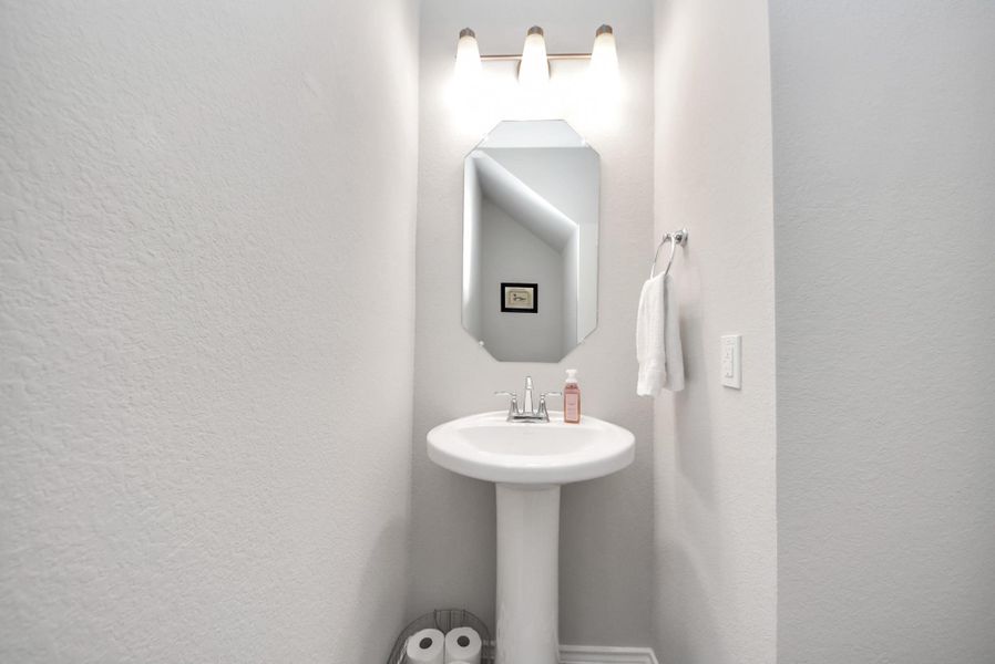Half bath that is located downstairs off of the living room. Perfect location for guests to use. Light and bright with hard surface flooring and pretty light fixture! Half bath that is located downstairs off of the living room. Perfect location for guests to use. Light and bright with hard surface flooring and pretty light fixture!