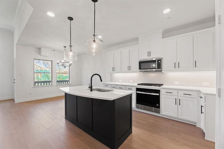 Kitchen featuring backsplash, a center island with sink, dark cabinets, white cabinetry, and recessed lighting Kitchen featuring backsplash, a center island with sink, dark cabinets, white cabinetry, and recessed lighting
