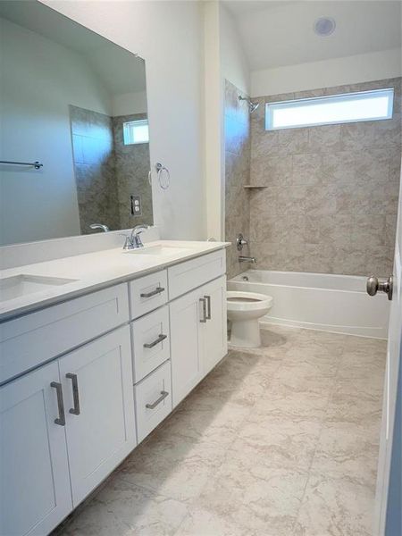 Full bath with lofted ceiling, toilet, a sink, double vanity, and washtub / shower combination