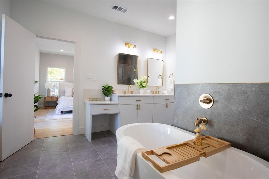 Bathroom with tile patterned floors, vanity, and a bathtub