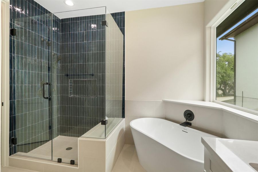Bathroom with tile walls, a freestanding tub, a stall shower, and vanity Bathroom with tile walls, a freestanding tub, a stall shower, and vanity
