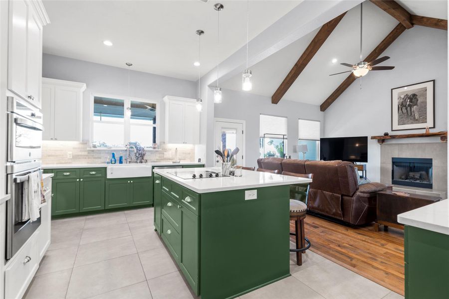 Dual tone kitchen featuring dual tone cabinets, a center island, open floor plan, light tile patterned floors, and a breakfast bar area