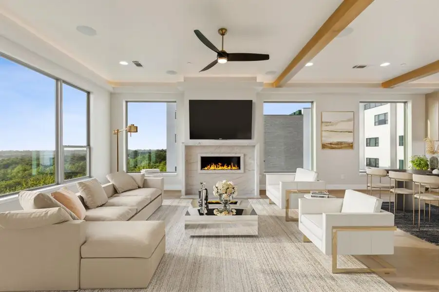 Living room with a premium fireplace, wood finished floors, ceiling fan, beam ceiling, and baseboards