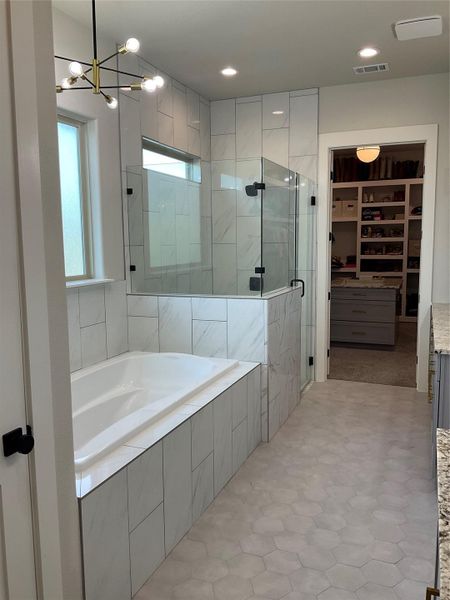 spa like bathroom with extra large soaker tub and separate shower with seat