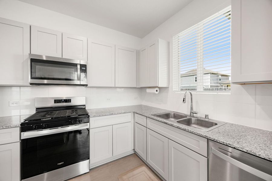 Soft-close cabinetry, granite countertops, and stainless steel appliances create a modern, move-in ready kitchen that blends beauty with practicality.