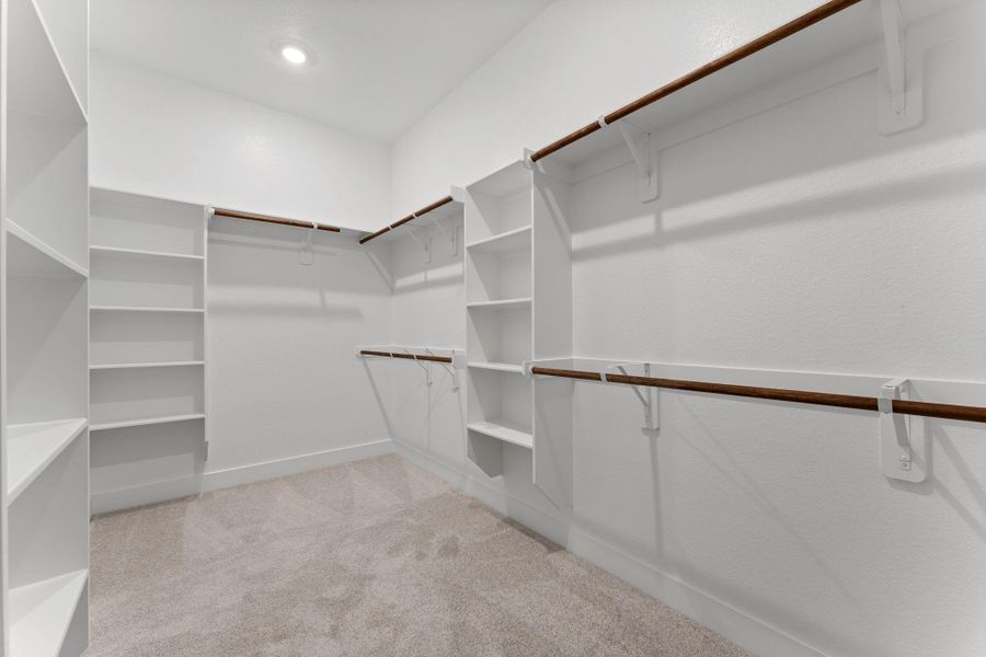Massive walk-in primary closet with abundant hanging space, and built-in shelving. Massive walk-in primary closet with abundant hanging space, and built-in shelving.
