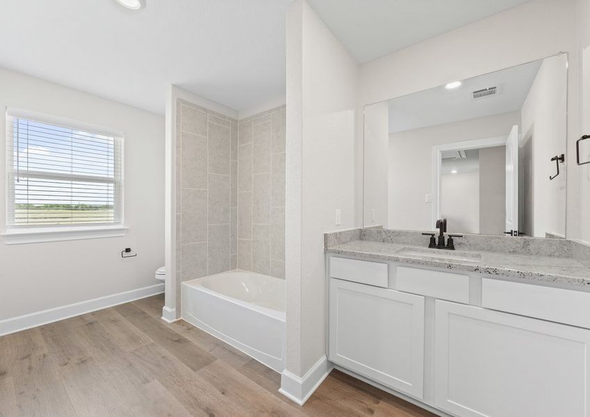 The secondary bathroom of the Cypress floor plan has a large vanity and shower-tub combo.